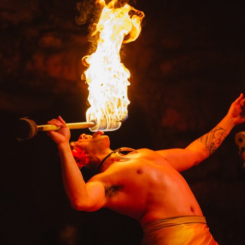 Two men on stage breathing fire