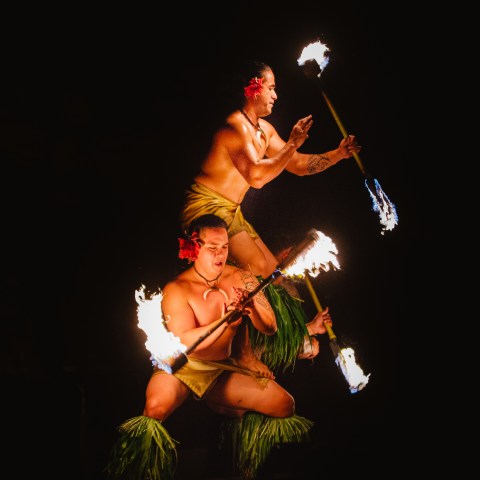 Three men spinning knives lit on fire